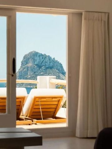 Terrasse mit Sonnenliegen und Blick auf Felsen im Meer