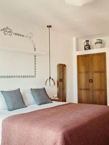 Gemütliches Schlafzimmer mit rosa Überwurf und erdigen Holzakzenten