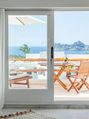 Terrasse mit Blick auf das Meer und Holzmöbeln, ideales Entspannungserlebnis.