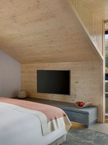 Gemütliches Zimmer mit Holzverkleidung und elegantem Bett im Six Senses Douro Valley Hotel