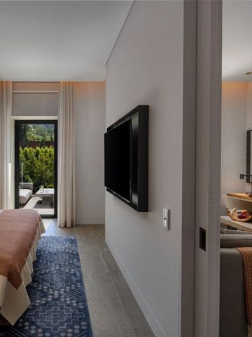 Elegantes Hotelzimmer mit Zugang zu einer Terrasse durch eine Glastür