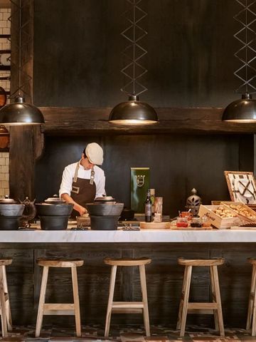 Gemütliche Hotelbar mit rustikalem Dekor und einem Barkeeper bei der Arbeit