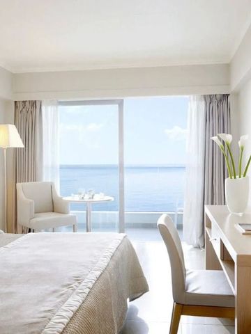 Helles Hotelzimmer mit Meerblick und eleganter Dekoration.
