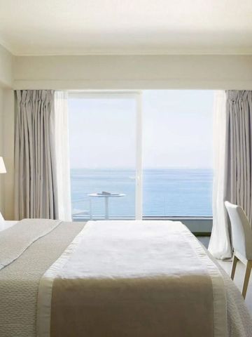 Komfortables Hotelzimmer mit großem Fenster und Meerblick.