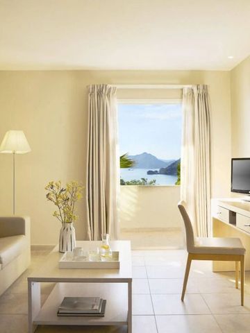 Modernes Wohnzimmer mit Fenster zum Meer und stilvoller Möblierung.