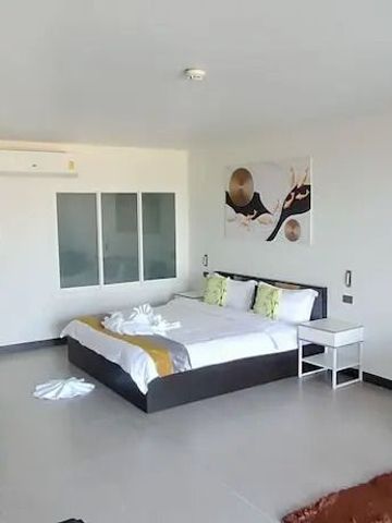 Geräumiges Schlafzimmer mit stilvoller Einrichtung und Kunst an der Wand