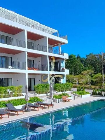 Modernes Hotelgebäude mit Pool und Sonnenliegen vor einem klaren blauen Himmel