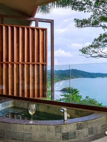Privater Whirlpool mit Blick auf tropische Küste und bewaldete Hügel