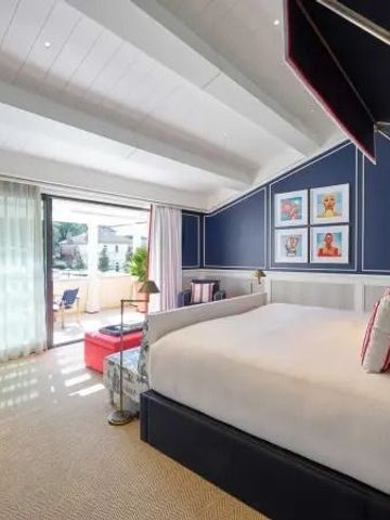 Helles Hotelzimmer mit großem Bett und Zugang zur Terrasse