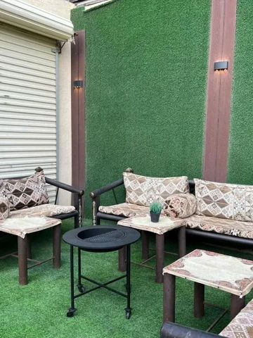 Gemütliche Terrasse mit stilvollen Sitzmöbeln und grünem Kunstrasen