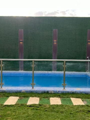 Kleiner privater Pool umgeben von gepflegtem Rasen und moderner Umzäunung