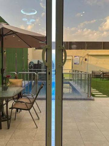 Blick durch Glastür auf Terrasse mit Pool und Sitzbereich