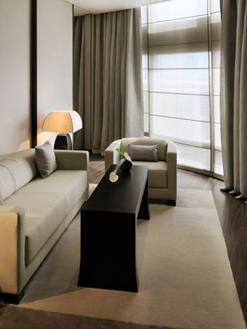 Luxuriöses Wohnzimmer in einer Hotelsuite mit Sofa und großen Fenstern