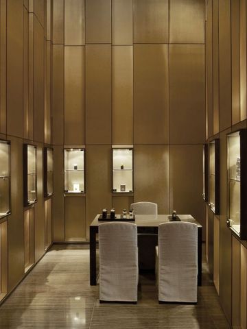 Exklusiver Raum mit goldenen Wänden und moderner Tischanordnung