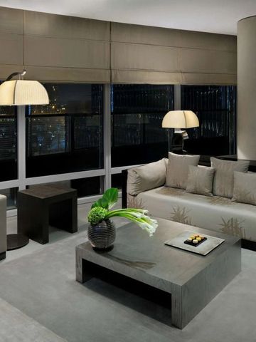 Elegante Suite mit modernen Möbeln und Stadtblick im Hintergrund.