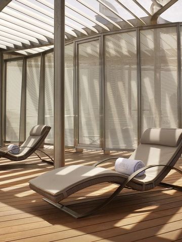 Terrasse mit stilvollen Liegestühlen und moderner Architektur.