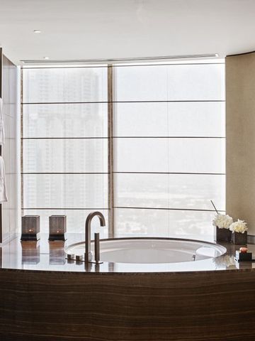 Hochwertiges Badezimmer mit freistehender Badewanne und Stadtpanorama.