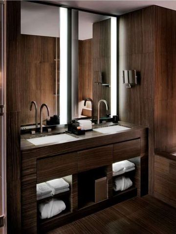 Modernes Badezimmer mit Doppelwaschbecken und warmen Holzelementen.