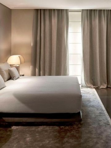 Elegantes Doppelzimmer mit grauen Vorhängen und sanfter Beleuchtung