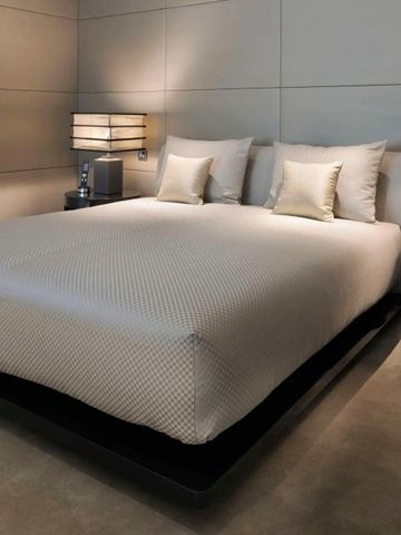 Modernes Schlafzimmer mit gemütlicher Beleuchtung und eleganter Bettwäsche