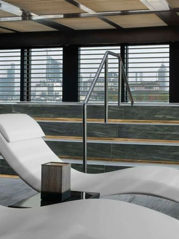 Innenbereich eines modernen Wellnessbereichs mit Liegen und Stadtblick
