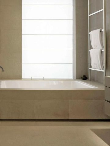 Zeitgemäßes Badezimmer mit freistehender Badewanne und Fenster