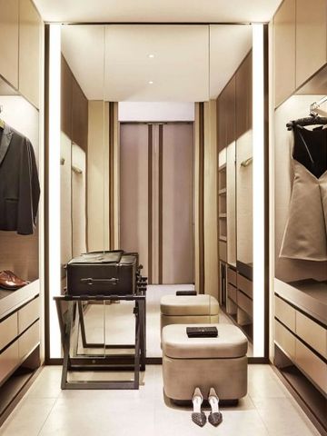 Geräumiger begehbarer Kleiderschrank mit eleganter Beleuchtung.