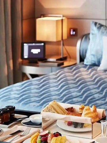 Hotelzimmer mit elegantem Bett und Frühstückstablett.