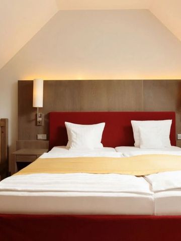 Gemütliches Dachzimmer mit Holzverkleidung und Doppelbett