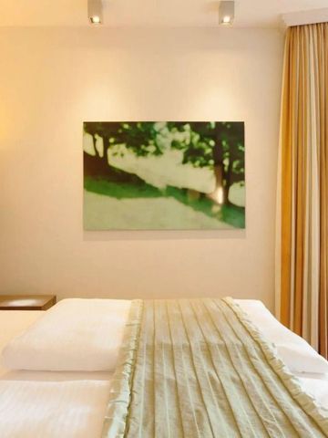 Hotelzimmer mit grünem Gemälde und natürlicher Beleuchtung