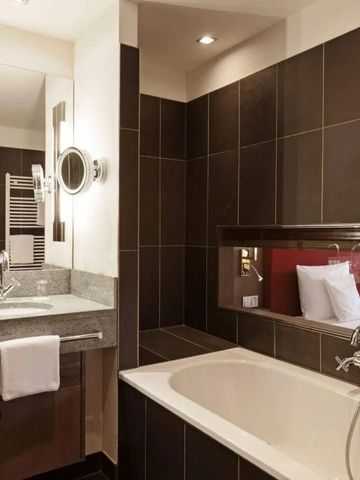 Geräumiges Badezimmer mit Badewanne und stilvollem Doppelwaschtisch.