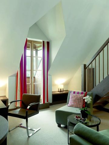 Elegantes Hotelzimmer mit Dachschräge und moderner Einrichtung