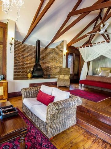 Zimmer im Arusha Coffee Lodge mit Himmelbett und Kamin für romantische Atmosphäre