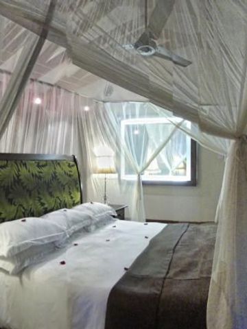 Elegantes Schlafzimmer mit Baldachinbett im Arusha Coffee Lodge Hotel