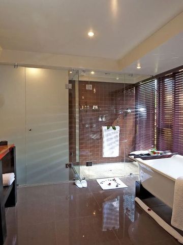 Stilvolles Badezimmer mit Badewanne und großer Glasdusche