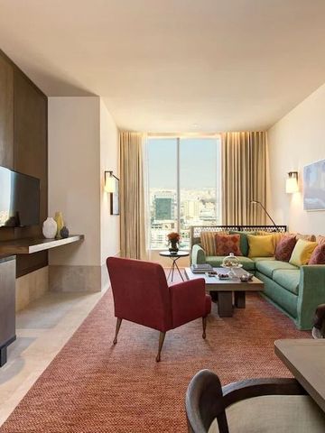 Elegantes Wohnzimmer in einer Hotelsuite mit moderner Ausstattung und Stadtblick