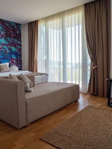 Helles Hotelzimmer mit künstlerischer Wandgestaltung und Sitzecke