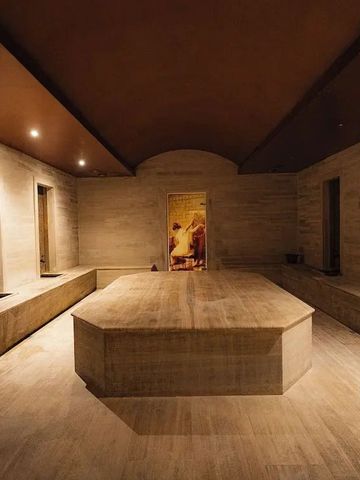 Geräumiger Wellnessbereich mit warm beleuchteten Natursteinwänden