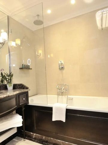 Elegantes Badezimmer mit Badewanne und Marmorwaschbecken im Hotel Auberge du Jeu de Paume