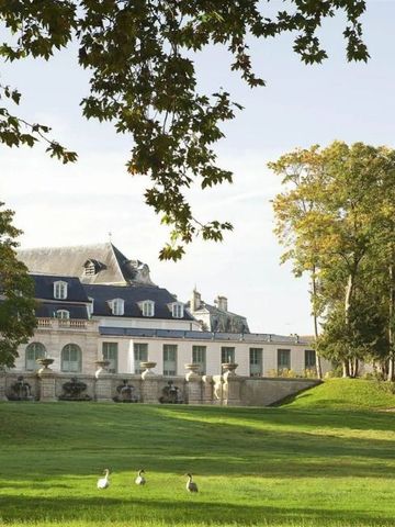 Historische Fassade des Hotels Auberge du Jeu de Paume in grüner Parklandschaft