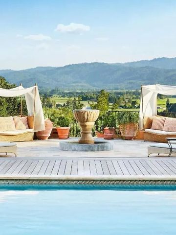 Luxuriöser Poolbereich mit bequemen Liegen und Blick auf die umliegenden Hügel.