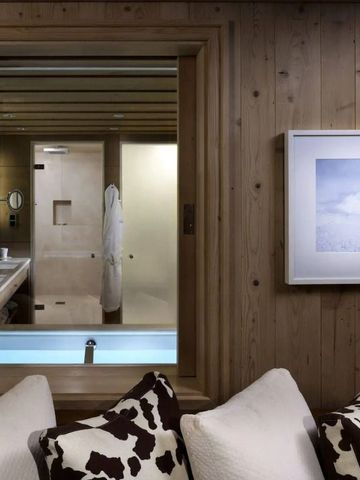 Blick ins luxuriöse Badezimmer durch Holzfenster mit Kunstrahmen an der Wand