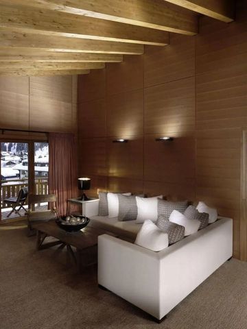 Holzverkleidetes Wohnzimmer mit großen Fenstern und Terrasse