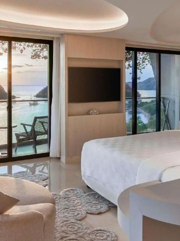 Luxuszimmer mit Panoramafenstern und Meerblick bei Sonnenuntergang