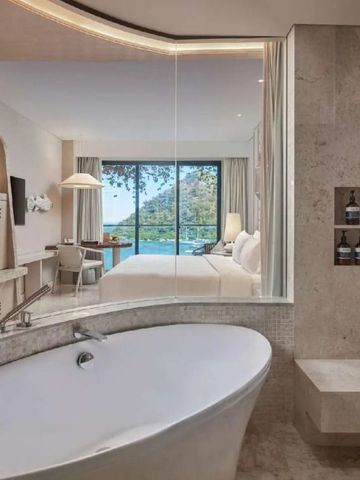 Geräumiges Bad mit freistehender Wanne und Blick ins Schlafzimmer