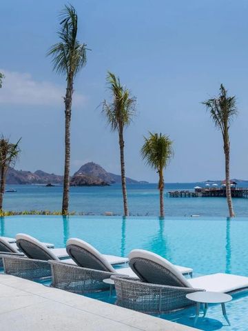 Infinity Pool mit Liegestühlen und Meerblick bei klarem Himmel