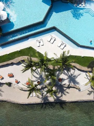 Vogelperspektive auf Strand und Poolbereich mit Palmen und Liegen