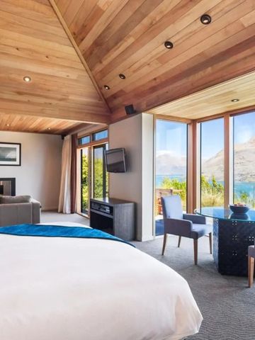 Luxuriöse Suite mit Holzdecke und Panoramafenster mit Blick auf den See