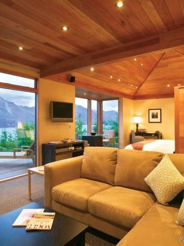 Offenes Wohnzimmer mit großen Fenstern. Aussicht auf Berglandschaft und Terrasse