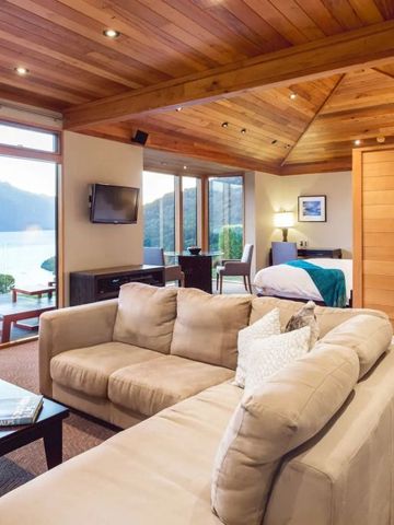 Luxuriöse Suite mit Holzakzenten und Panoramablick auf See und Berge